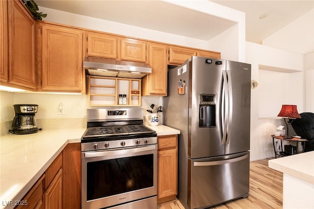 945 Stetson Dr, Henderson, NV 89002 - kitchen with stainless steel appliances, under cabinet range hood, light countertops, and light wood finished floors