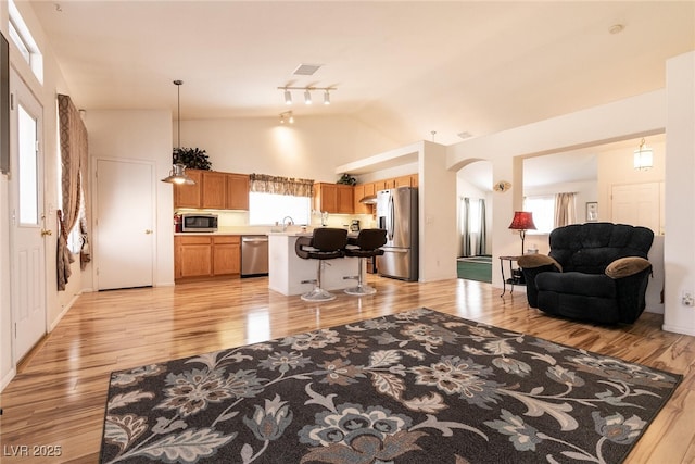 945 Stetson Dr, Henderson, NV 89002 - living room with light wood-style flooring, vaulted ceiling, and arched walkways