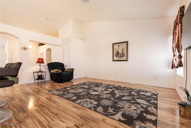 945 Stetson Dr, Henderson, NV 89002 - living area featuring arched walkways, wood finished floors, and high vaulted ceiling