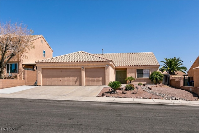 945 Stetson Dr, Henderson, NV 89002 - view of front facade featuring an attached garage, a tile roof, stucco siding, and driveway