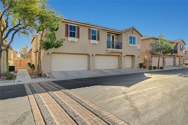 6255 W Arby Ave Unit 258, Las Vegas, NV 89118 - view of front of house with stucco siding, an attached garage, driveway, and a tiled roof