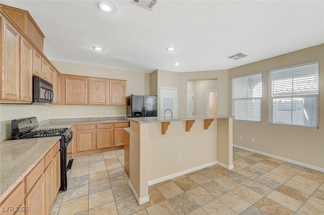 6255 W Arby Ave Unit 258, Las Vegas, NV 89118 - kitchen featuring black appliances, a kitchen breakfast bar, recessed lighting, stone tile flooring, and baseboards