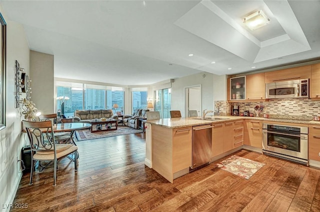 222 Karen Ave Unit 601, Las Vegas, NV 89109 - kitchen featuring stainless steel appliances, light brown cabinetry, hardwood / wood-style floors, a peninsula, and open floor plan