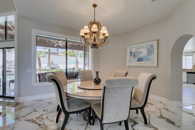 2101 Diamond Bar Dr, Las Vegas, NV 89117 - dining area featuring arched walkways, a chandelier, light marble finish floors, and baseboards