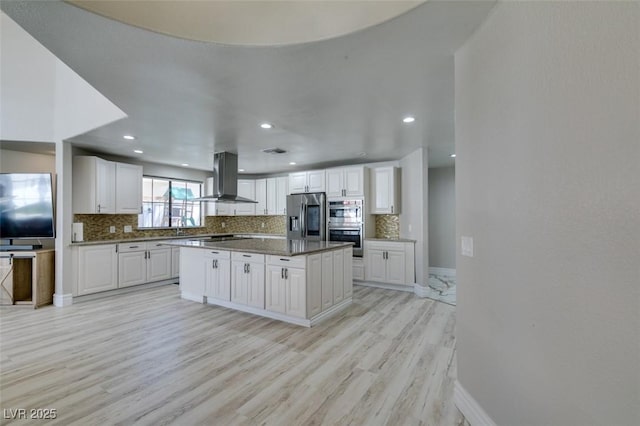 2101 Diamond Bar Dr, Las Vegas, NV 89117 - kitchen featuring island range hood, stainless steel appliances, decorative backsplash, white cabinets, and light wood-style flooring