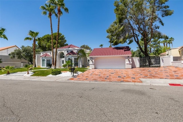 2101 Diamond Bar Dr, Las Vegas, NV 89117 - mediterranean / spanish-style home with a tiled roof, an attached garage, stucco siding, driveway, and a gate