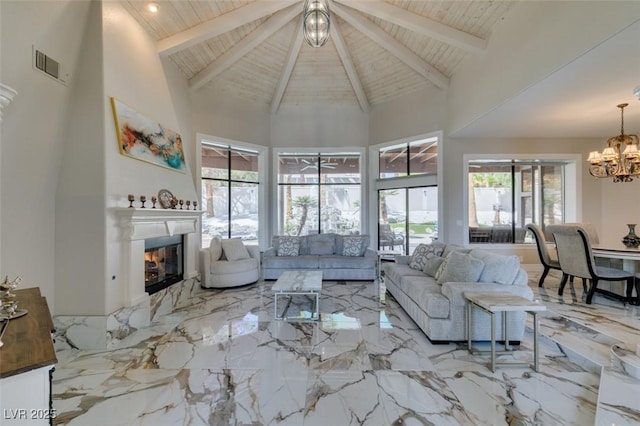 2101 Diamond Bar Dr, Las Vegas, NV 89117 - living area featuring a chandelier, high vaulted ceiling, a glass covered fireplace, marble tiled flooring, and wooden ceiling with exposed beams
