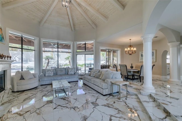 2101 Diamond Bar Dr, Las Vegas, NV 89117 - living room featuring arched walkways, wooden ceiling with exposed beams, high vaulted ceiling, plenty of natural light, and a glass covered fireplace
