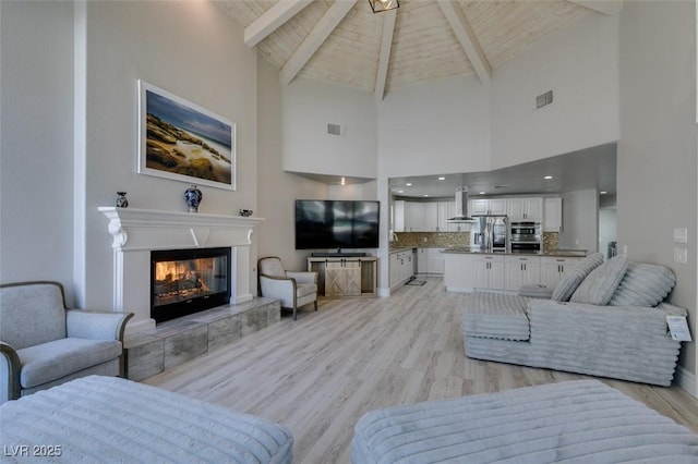 2101 Diamond Bar Dr, Las Vegas, NV 89117 - living area with light wood finished floors, high vaulted ceiling, a tile fireplace, and wooden ceiling with exposed beams