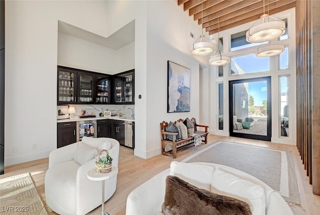 5155 Rock Daisy Dr, Las Vegas, NV 89135 - entryway with a towering ceiling, wet bar, wine cooler, light wood finished floors, and baseboards