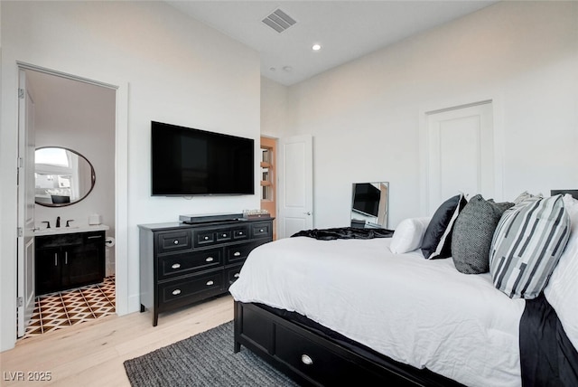 5155 Rock Daisy Dr, Las Vegas, NV 89135 - bedroom featuring light wood-style floors, connected bathroom, and a sink