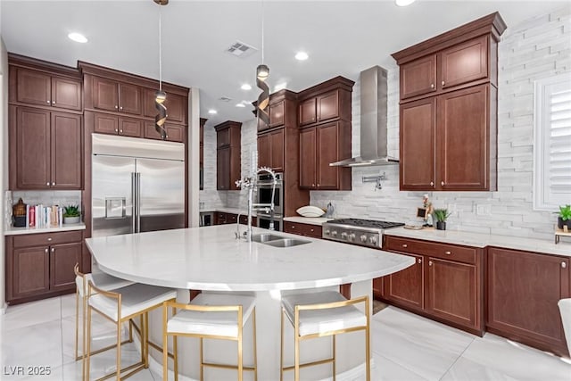 3929 Reyes Ave, Las Vegas, NV 89141 - kitchen with wall chimney range hood, a sink, stainless steel appliances, backsplash, and pendant lighting