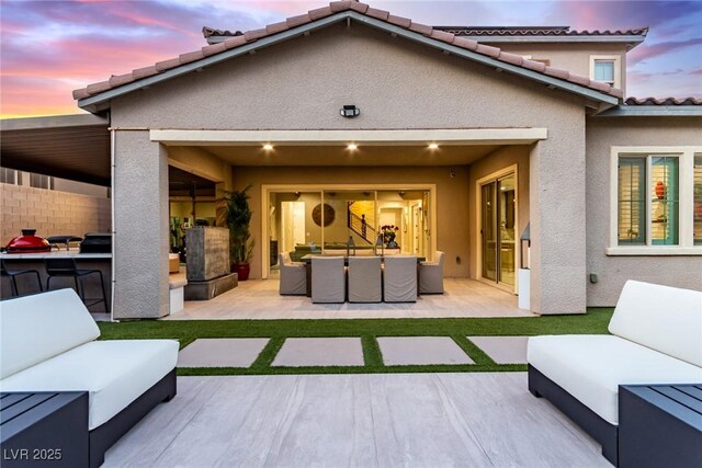 3929 Reyes Ave, Las Vegas, NV 89141 - back of property at dusk with an outdoor living space, stucco siding, and a patio area