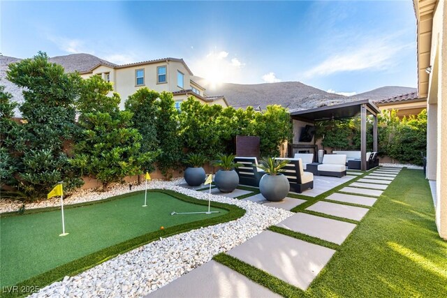 3929 Reyes Ave, Las Vegas, NV 89141 - view of yard featuring an area to practice putting, outdoor lounge area, a patio, and a mountain view