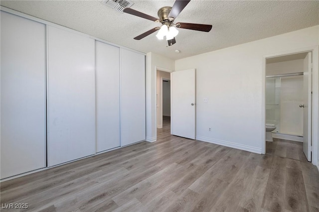 5535 Oxbow St, Las Vegas, NV 89119 - unfurnished bedroom with a closet, light wood-style flooring, a textured ceiling, ensuite bathroom, and a ceiling fan