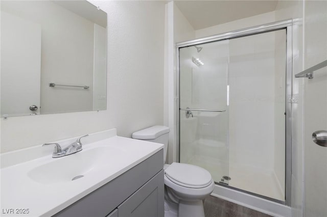 5535 Oxbow St, Las Vegas, NV 89119 - bathroom featuring a stall shower, vanity, toilet, and wood finished floors