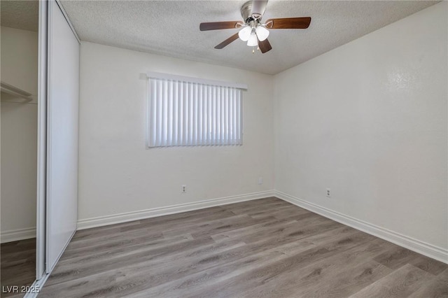 5535 Oxbow St, Las Vegas, NV 89119 - unfurnished bedroom with a closet, a textured ceiling, wood finished floors, baseboards, and ceiling fan