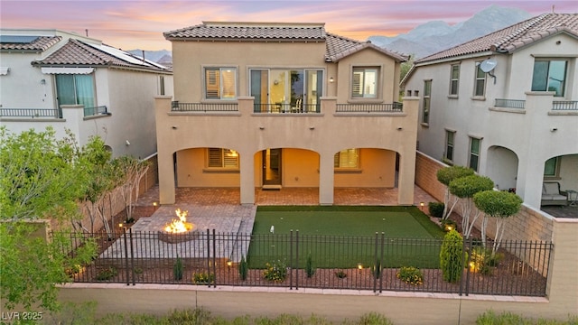 424 Vigo Port St, Las Vegas, NV 89138 - rear view of house with a patio, a fire pit, stucco siding, a fenced backyard, and a balcony