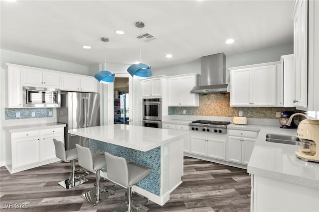 424 Vigo Port St, Las Vegas, NV 89138 - kitchen with wall chimney exhaust hood, stainless steel appliances, a sink, a kitchen island, and a kitchen breakfast bar