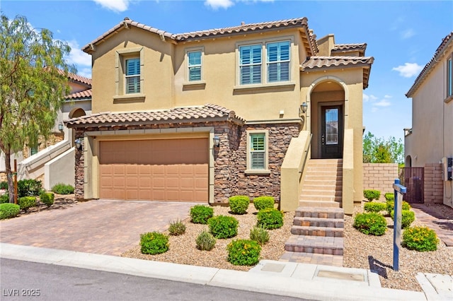 424 Vigo Port St, Las Vegas, NV 89138 - mediterranean / spanish-style house featuring stucco siding, an attached garage, a tile roof, decorative driveway, and stone siding