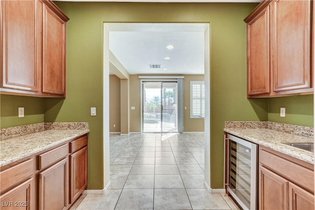 5949 Casa Coronado Ave, Las Vegas, NV 89131 - kitchen featuring beverage cooler, light tile patterned floors, baseboards, and light stone countertops
