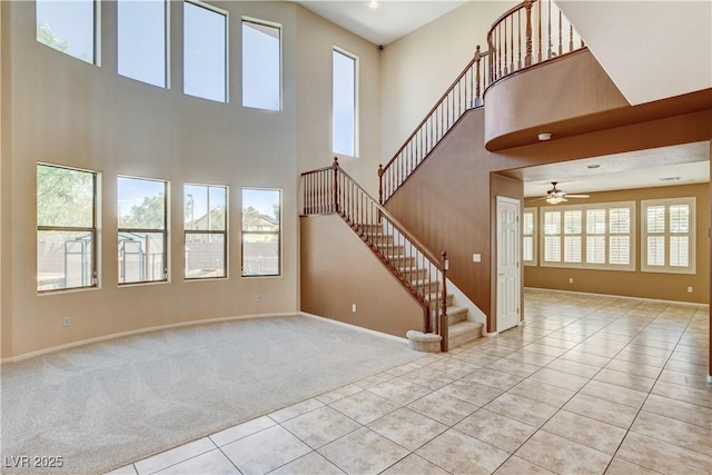 5949 Casa Coronado Ave, Las Vegas, NV 89131 - unfurnished living room with stairway, a towering ceiling, tile patterned flooring, carpet floors, and baseboards