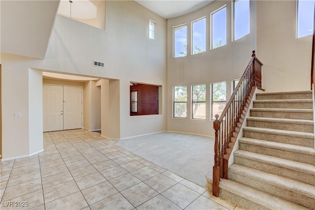 5949 Casa Coronado Ave, Las Vegas, NV 89131 - unfurnished living room with a towering ceiling, stairway, baseboards, and light tile patterned floors