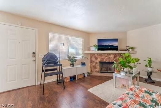 904 Boulder Springs Dr Unit 102, Las Vegas, NV 89128 - living area with wood finished floors, a stone fireplace, and baseboards