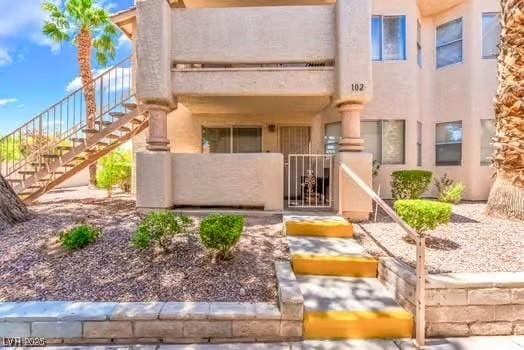 904 Boulder Springs Dr Unit 102, Las Vegas, NV 89128 - view of front of home featuring stairway, a gate, and stucco siding