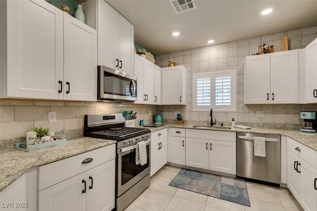 4519 Sapphire Moon Ave, North Las Vegas, NV 89084 - kitchen with stainless steel appliances, a sink, white cabinetry, tasteful backsplash, and recessed lighting