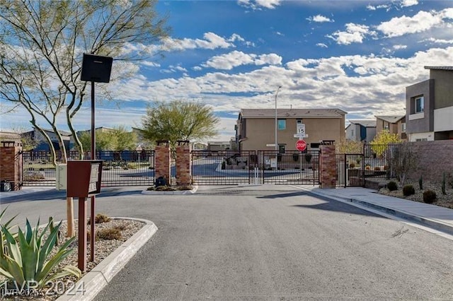 4519 Sapphire Moon Ave, North Las Vegas, NV 89084 - view of asphalt road featuring traffic signs, a gate, a residential view, and a gated entry