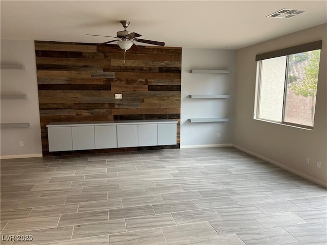 7265 Southern Magnolia St, Las Vegas, NV 89149 - unfurnished living room with a ceiling fan, wooden walls, and baseboards