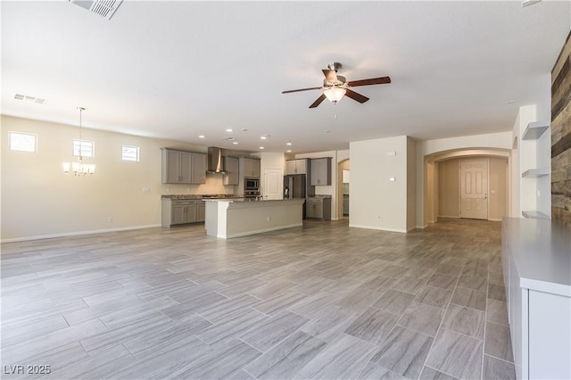 7265 Southern Magnolia St, Las Vegas, NV 89149 - unfurnished living room featuring a ceiling fan, arched walkways, baseboards, wood tiled floors, and recessed lighting
