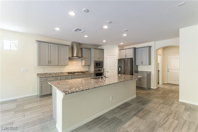 7265 Southern Magnolia St, Las Vegas, NV 89149 - kitchen with wall chimney exhaust hood, gray cabinetry, appliances with stainless steel finishes, arched walkways, and a sink