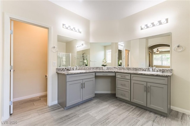 7265 Southern Magnolia St, Las Vegas, NV 89149 - bathroom with double vanity, a shower stall, wood finished floors, baseboards, and a ceiling fan