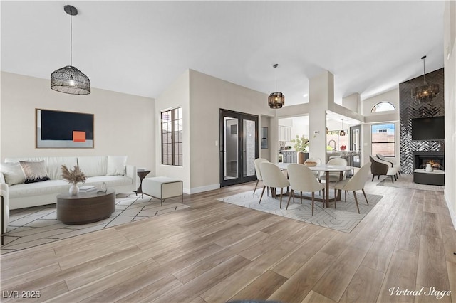 7221 W Washington Ave, Las Vegas, NV 89128 - dining space featuring wood finished floors, high vaulted ceiling, a fireplace, and baseboards