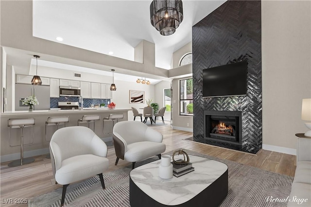 7221 W Washington Ave, Las Vegas, NV 89128 - living room featuring light wood finished floors, a high end fireplace, baseboards, recessed lighting, and vaulted ceiling
