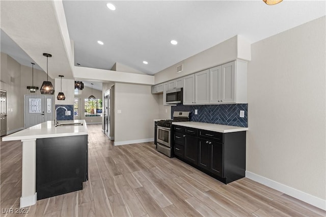 7221 W Washington Ave, Las Vegas, NV 89128 - kitchen with stainless steel appliances, a sink, lofted ceiling, light countertops, and baseboards