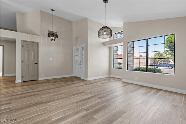 7221 W Washington Ave, Las Vegas, NV 89128 - unfurnished dining area with high vaulted ceiling, light wood-style floors, plenty of natural light, and baseboards