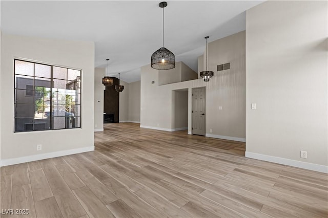7221 W Washington Ave, Las Vegas, NV 89128 - unfurnished living room featuring light wood finished floors, baseboards, and high vaulted ceiling