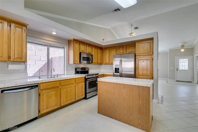 259 Baring Cross St, Henderson, NV 89074 - kitchen featuring stainless steel appliances, tile counters, ornamental molding, a sink, and light tile patterned flooring