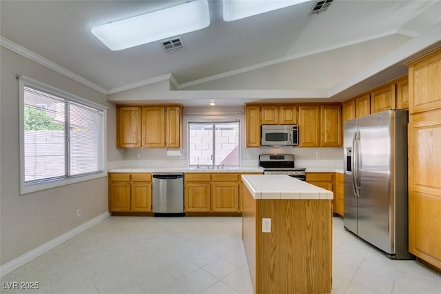 259 Baring Cross St, Henderson, NV 89074 - kitchen featuring stainless steel appliances, tile counters, lofted ceiling, a center island, and crown molding