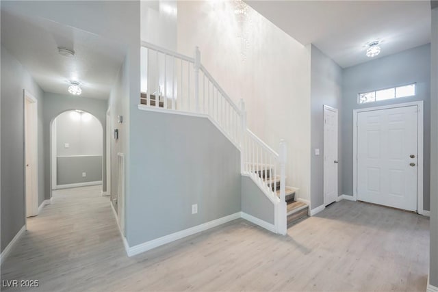 5133 Burr Oak Dr, Las Vegas, NV 89130 - entrance foyer featuring light wood-style flooring, arched walkways, stairway, and baseboards