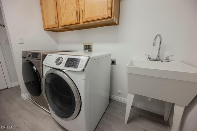 5133 Burr Oak Dr, Las Vegas, NV 89130 - laundry room featuring cabinet space, light wood-type flooring, independent washer and dryer, and baseboards