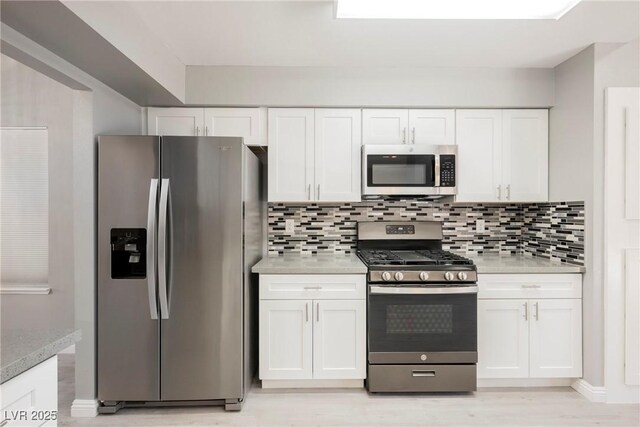 5133 Burr Oak Dr, Las Vegas, NV 89130 - kitchen featuring stainless steel appliances, white cabinetry, light countertops, and backsplash
