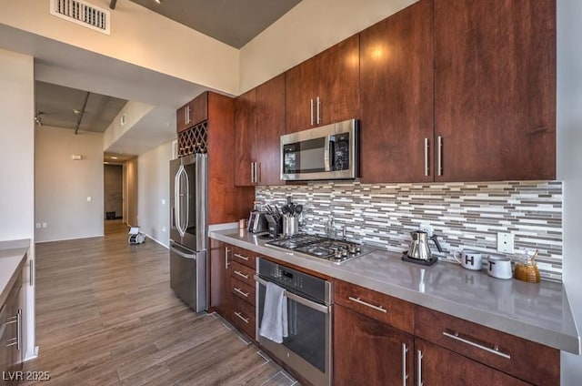 353 E Bonneville Ave Unit 379, Las Vegas, NV 89101 - kitchen featuring stainless steel appliances, wood finished floors, tasteful backsplash, and light countertops