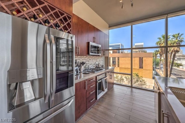 353 E Bonneville Ave Unit 379, Las Vegas, NV 89101 - kitchen featuring stainless steel appliances, a wall of windows, decorative backsplash, dark wood finished floors, and modern cabinets