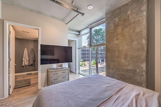 353 E Bonneville Ave Unit 379, Las Vegas, NV 89101 - bedroom with wood finished floors, access to exterior, and expansive windows