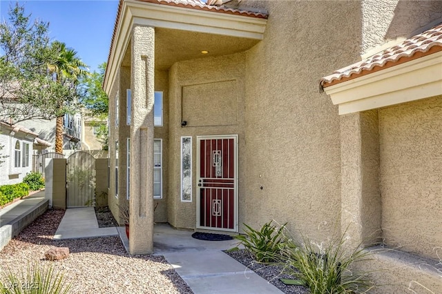1833 Winners Cup Dr, Las Vegas, NV 89117 - view of exterior entry featuring stucco siding, a gate, and a tile roof