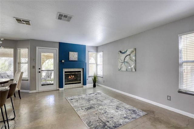 1833 Winners Cup Dr, Las Vegas, NV 89117 - living room featuring concrete floors, a tiled fireplace, and baseboards